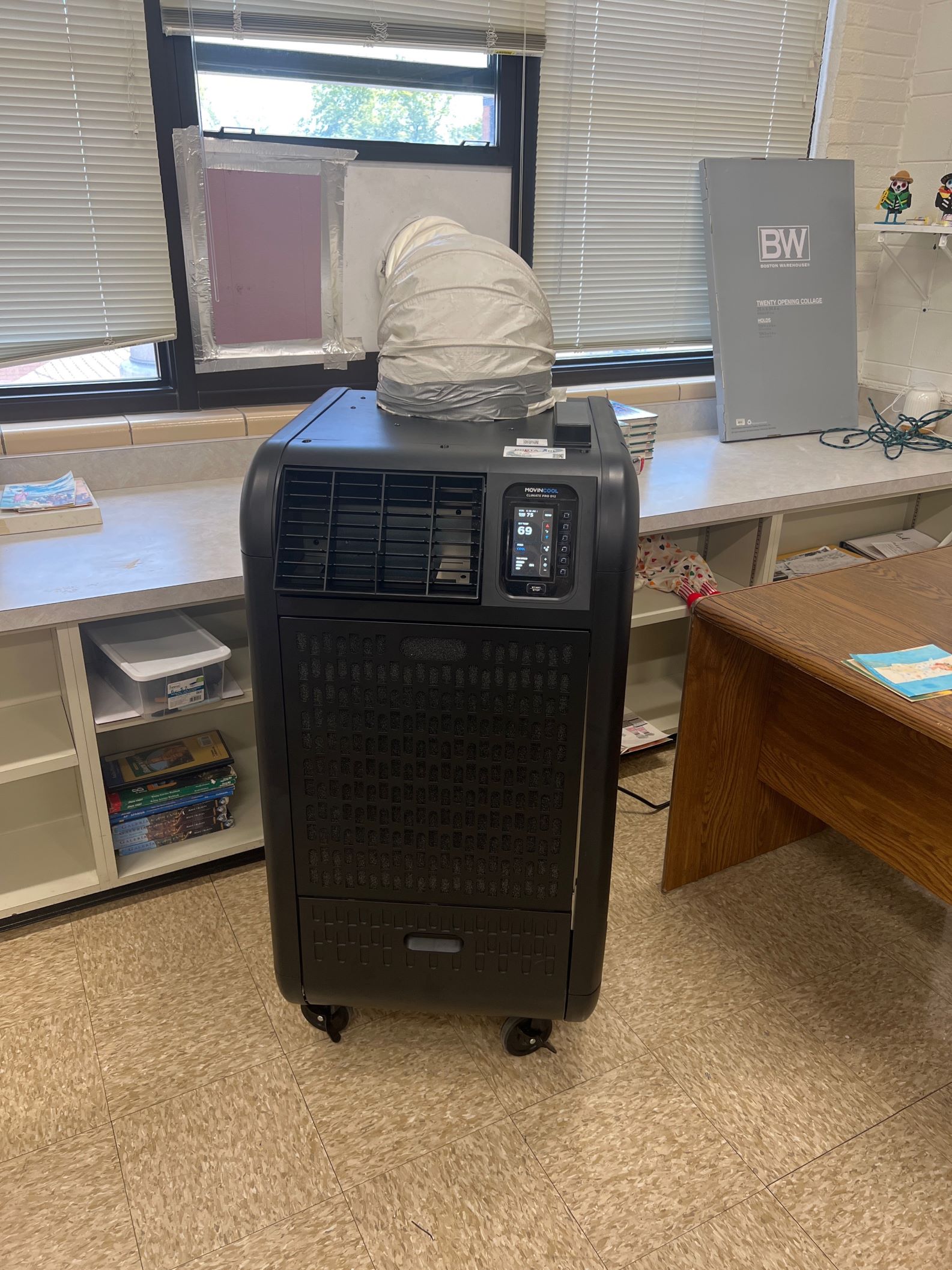 Black upright temporary HP unit in a school classroom cooling the area.  
